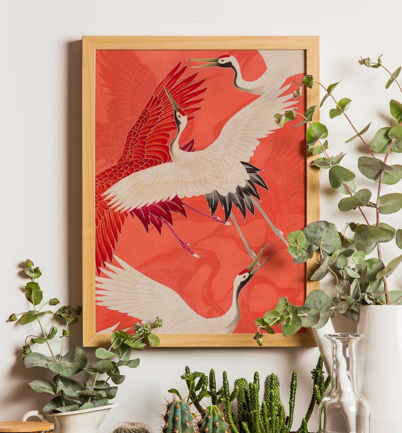 Red and white Japanese cranes in flight illustrated in a traditional Asian art style on a vibrant red background. Framed or unframed wall art.