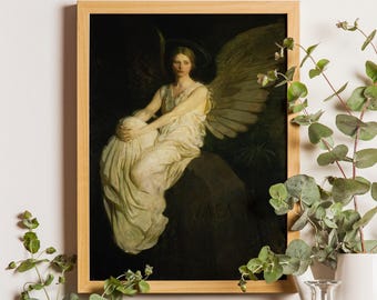 May include: A framed wall art print featuring a painting of a winged figure in a white robe sitting on a dark rock. The figure has large feathered wings and a halo. The word VAEA is inscribed on the rock. The frame is light-colored wood.