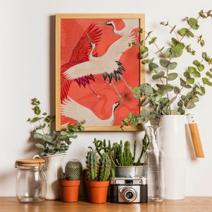 Red and white Japanese cranes in flight illustrated in a traditional Asian art style on a vibrant red background. Framed or unframed wall art.