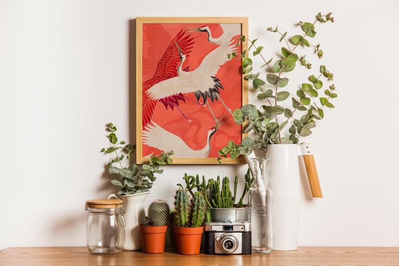 Red and white Japanese cranes in flight illustrated in a traditional Asian art style on a vibrant red background. Framed or unframed wall art.