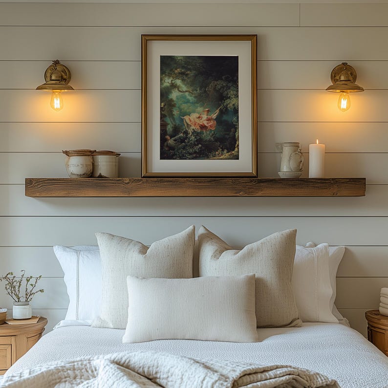 Fragonard The Swing L'Escarpolette Rococo art print, gold float frame white mat, on dark wood floating picture ledge shelf above neutral linen bed, twin brass Edison bulb wall sconces white shiplap, farmhouse romantic bedroom wall decor