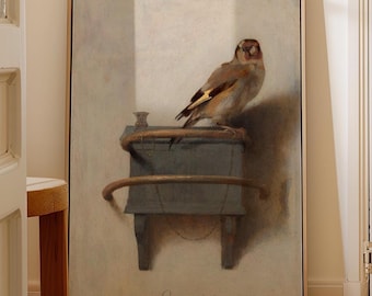 May include: A framed wall art print featuring a painting of a goldfinch perched on a blue wooden feeder. The bird has brown, white, and yellow feathers. The painting includes the text C FABRITIVS 1654 at the bottom against a light background.