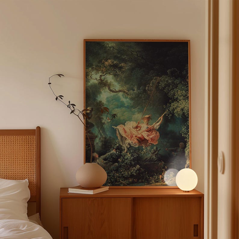 Fragonard The Swing Jean-Honoré Fragonard French Rococo art print, natural oak float frame, leaning on mid-century teak sideboard, rattan cane headboard round ceramic vase globe bedside lamp, romantic boho bedroom wall art classical painting reproduction