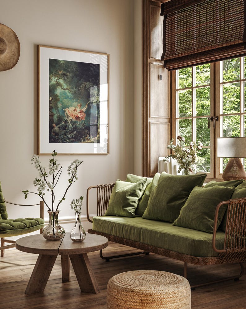 Fragonard The Swing L'Escarpolette French Rococo painting giclée print, natural oak wood frame white mat, hung on beige wall above olive green velvet rattan sofa wicker armchair, bamboo roman blind large French window white blossom, romantic cottagecore nature lover living room wall art