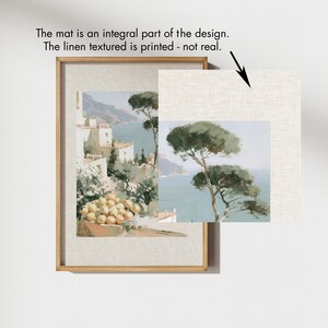 Close-up detail showing the printed linen texture mat on an Amalfi Coast art print in a natural wood frame — annotation text reads 'The mat is an integral part of the design, the linen texture is printed, not real' — beside it a loose unframed print showing the same linen-textured paper