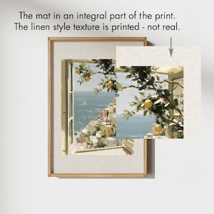 May include: Framed art print featuring a coastal scene with a window view of a town and sea. The artwork includes a linen-style texture printed on the mat. The image shows a branch with lemons.