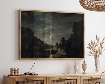 May include: A framed landscape painting depicting a dark, moody night scene with a full moon reflecting over a calm river, surrounded by silhouettes of trees and small buildings, all enclosed in a simple light-toned wooden frame.