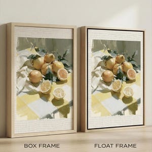 May include: Two framed art prints featuring a still life of lemons. The artwork depicts whole and sliced lemons with green leaves on a yellow and white checkered surface. The frames are labeled "BOX FRAME" and "FLOAT FRAME".