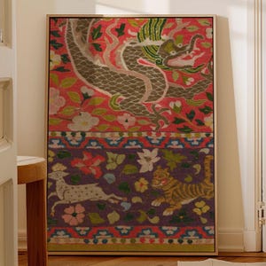 May include: Framed textile art featuring a dragon and other creatures. The top half has a red background with a gray dragon and floral accents. The bottom half has a purple background with a deer, tiger, and flowers. The frame is gold.