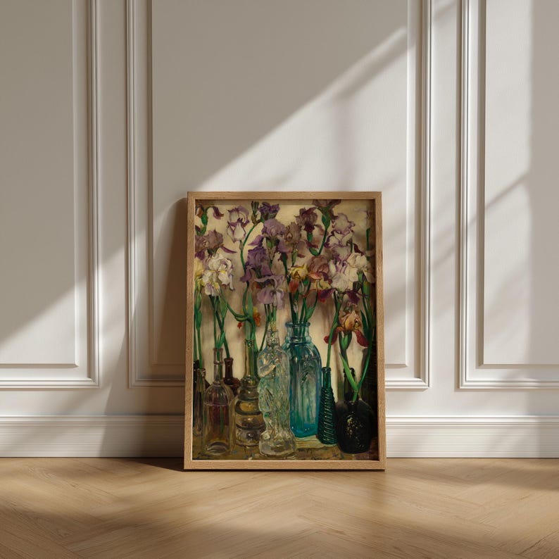 ramed vintage flower wall art print displayed in a cozy interior setting, reproduced from Frederick Judd Waugh’s 1922 Rum Row floral still life. The botanical artwork features classic early twentieth-century style with natural colors and refined detail, ideal for cottagecore, traditional, or antique-inspired home decor.
