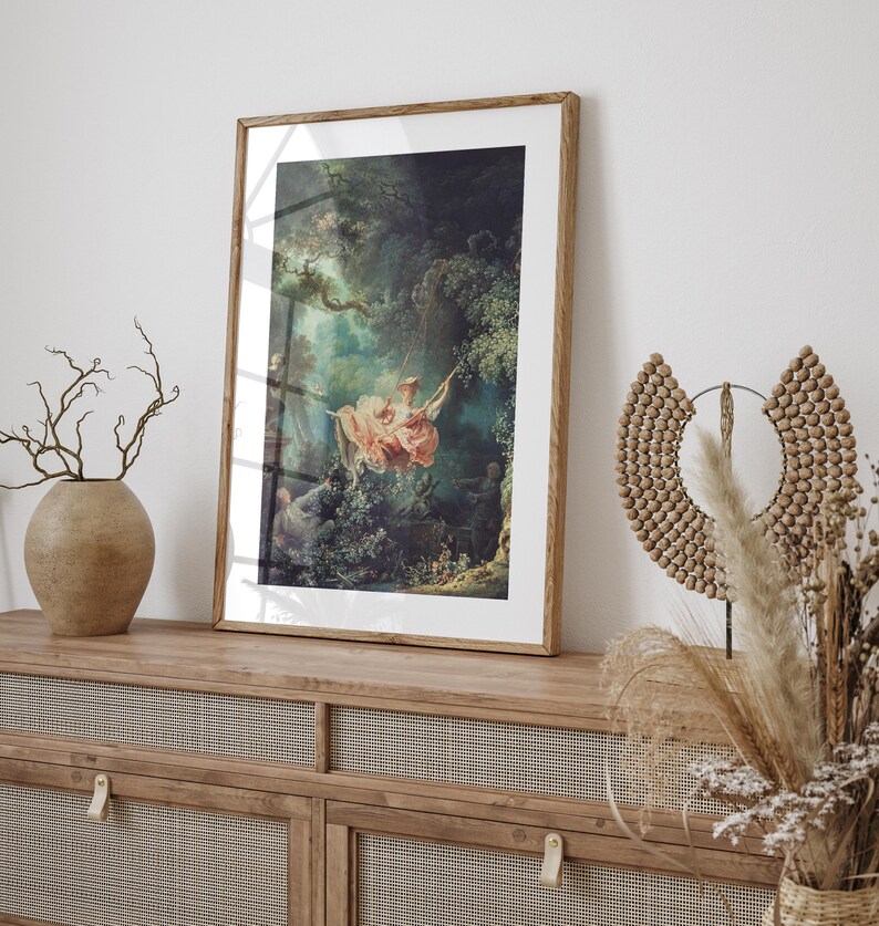 Fragonard The Swing Jean-Honoré Fragonard Rococo art print, natural oak wood frame white mat, leaning on rattan cane sideboard, ceramic vase dried branches pampas grass wicker sculptural moon decor, boho cottagecore romantic French wall art