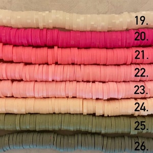 Puede incluir: Primer plano de una fila de cuentas de arcilla polim&eacute;rica de colores. Las cuentas est&aacute;n dispuestas en un degradado de blanco a rosa a verde. Las cuentas son todas del mismo tama&ntilde;o y forma, y son perfectas para hacer joyas u otras manualidades.