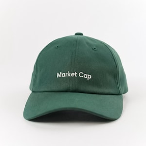 May include: A dark green baseball cap with the text "Market Cap" embroidered in white on the front. The cap has a curved brim and a classic six-panel design. The hat is made of a soft, durable fabric.