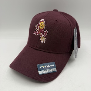 May include: A maroon baseball cap with a fitted 7 1/8 size. The cap features an embroidered logo of a devil with a pitchfork in gold, white, and maroon. The cap has a curved brim and a button on top.