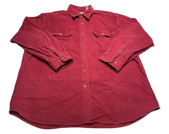 May include: A long-sleeved, button-down shirt in a deep burgundy red color. The shirt has two chest pockets with button closures and a button-up front.