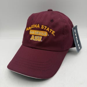 May include: A maroon baseball cap with the text "ARIZONA STATE SUN DEVILS ASU" embroidered in gold. The cap has a curved brim with a white underside and a small tag attached.