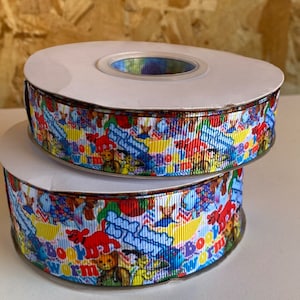 May include: Two spools of colorful ribbon with a repeating pattern of cartoon animals and the words "Bookworm" and "Read to Me".