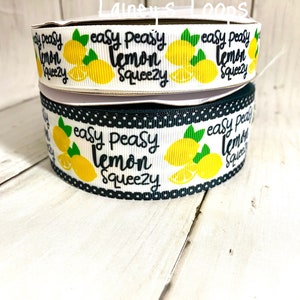 May include: Two rolls of white ribbon with black polka dots and a lemon print. The ribbon has the text "easy peasy lemon squeezy" printed on it.