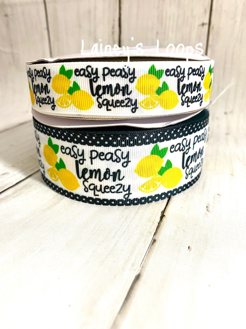 May include: Two rolls of white ribbon with black polka dots and a lemon print. The ribbon has the text "easy peasy lemon squeezy" printed on it.