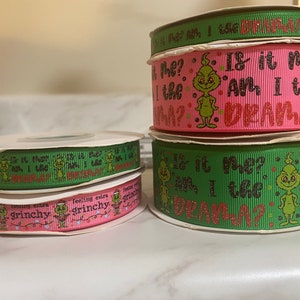 May include: Four spools of green and pink ribbon with a Grinch design. The ribbon has the text "Is it me? Am I the drama?" and "Feeling extra Grinchy".