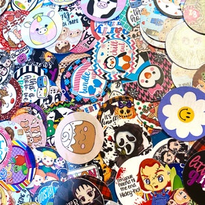 May include: A collection of colorful round stickers with various designs, including cartoon characters, animals, and text. The stickers are arranged in a random pattern and feature a variety of colors, such as pink, blue, green, yellow, and red.