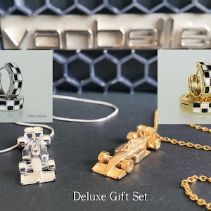 Puede incluir: Un lujoso juego de regalo con collares con colgantes de coche de carreras plateados y dorados, y pendientes de aro a juego con esmalte a cuadros blanco y negro. El texto "Deluxe Gift Set" es visible.