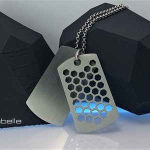 May include: Two silver dog tags on a silver chain. One tag is plain and the other has a honeycomb pattern.