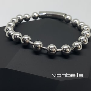 May include: A silver beaded bracelet with a magnetic clasp. The bracelet is made of round metal beads and has a simple, modern design.
