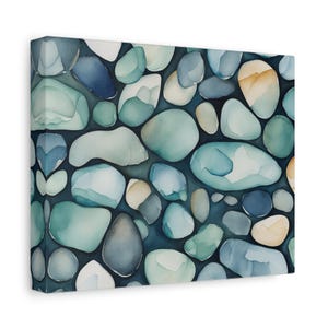 May include: A rectangular canvas wall art piece featuring a repeating pattern of smooth, rounded river stones in shades of teal, navy blue, light gray, and soft beige, arranged closely together against a dark, deep blue background.