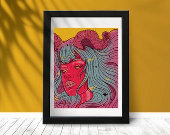 May include: Framed art print featuring a stylized illustration of a red-skinned figure with closed eyes, pink horns, and flowing blue hair. The artwork has a yellow background and is framed in a black frame. The art is displayed on a white wooden surface.