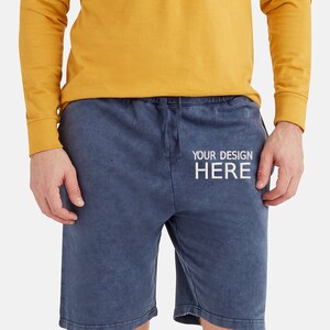 May include: A pair of blue drawstring shorts with the text "YOUR DESIGN HERE" printed on the front.