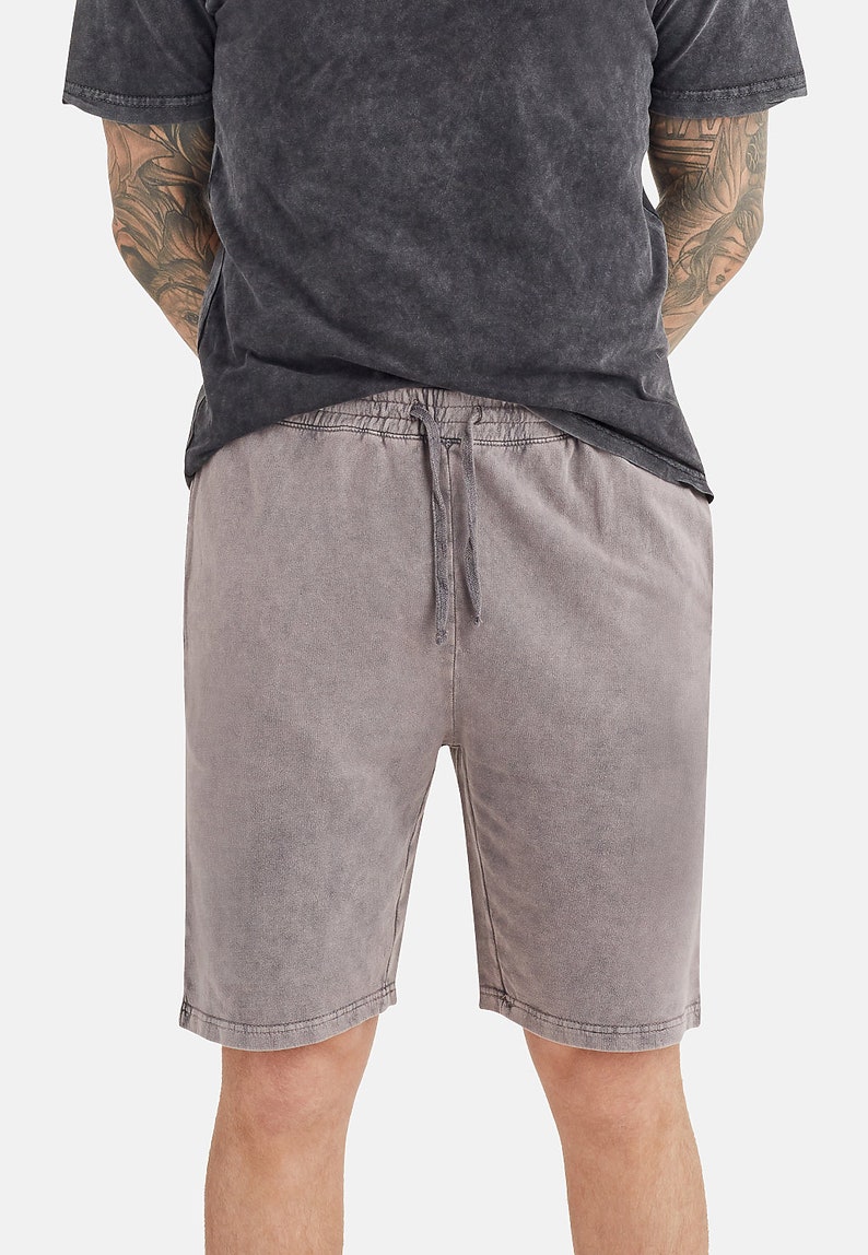 May include: A pair of grey drawstring shorts with a faded, vintage look.