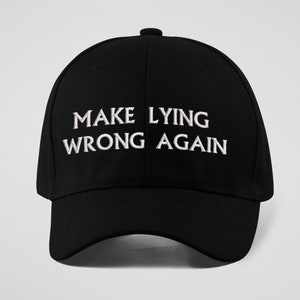 May include: A black baseball cap with white embroidery that reads "MAKE LYING WRONG AGAIN".
