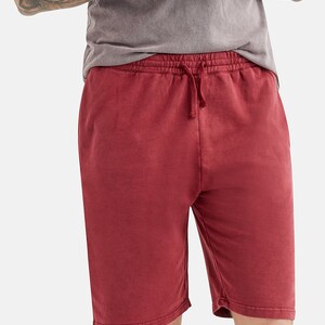 May include: Red drawstring shorts made from a soft, comfortable fabric. The shorts have a relaxed fit and a slightly distressed look.