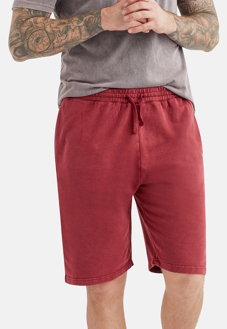 May include: Red drawstring shorts made from a soft, comfortable fabric. The shorts have a relaxed fit and a slightly distressed look.