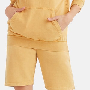 May include: A mustard yellow hoodie and matching shorts set. The hoodie has a kangaroo pocket and the shorts have a relaxed fit.
