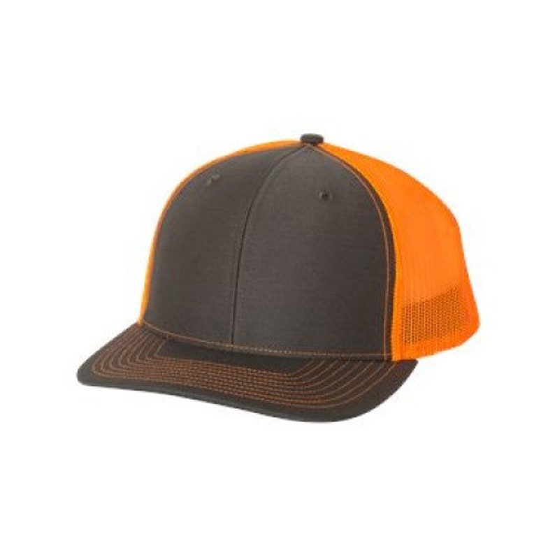 May include: A charcoal grey and orange trucker hat with a mesh back.