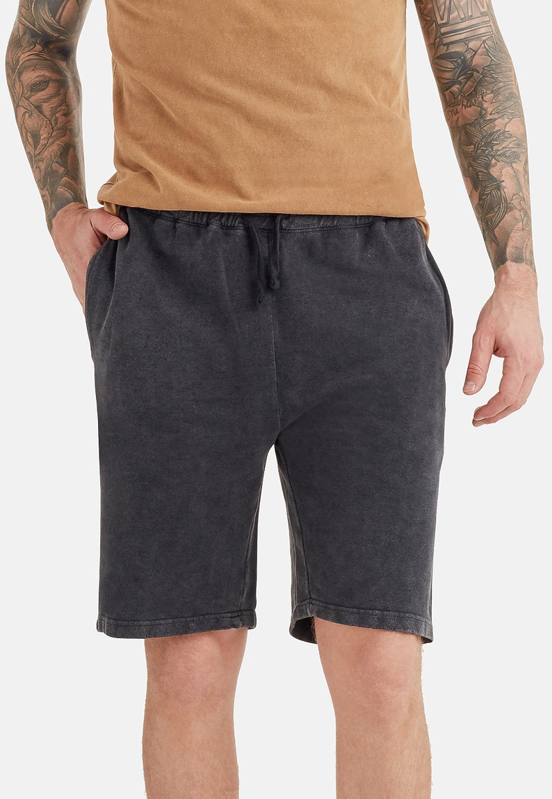 May include: Black drawstring shorts with a distressed look. The shorts have a relaxed fit and are made of a soft, comfortable fabric.