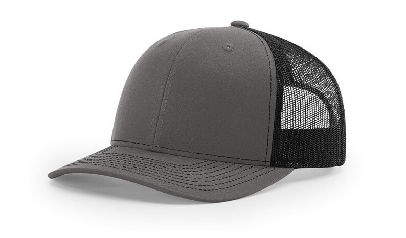 May include: A grey and black trucker hat with a mesh back. The hat has a curved brim and a structured crown.