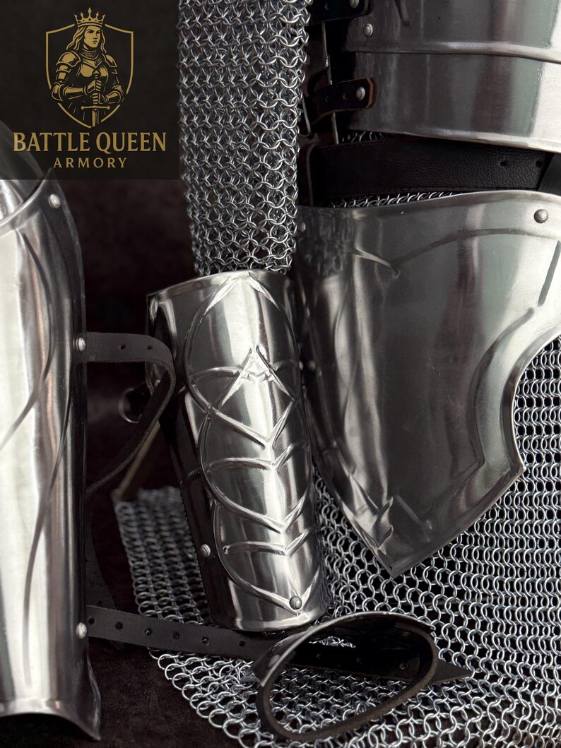 May include: Close-up of medieval armor components, including a polished metal arm guard with a leaf design, a chainmail shirt, and a shoulder plate. The image features the "Battle Queen Armory" logo in the upper left corner.
