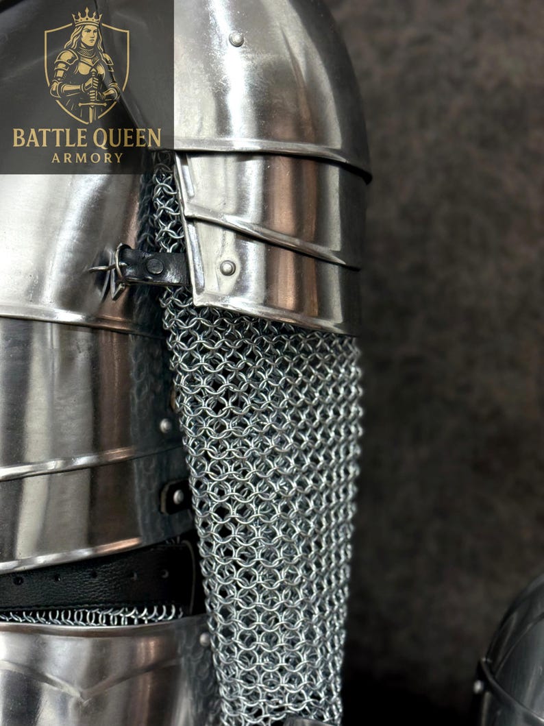 May include: Close-up of medieval armor, featuring polished metal plates and chainmail. The armor includes a shoulder guard and a section of chainmail, with the "BATTLE QUEEN ARMORY" logo visible in the upper left corner.