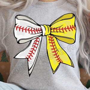 May include: A gray sweatshirt with a white and yellow softball bow design. The bow has red stitching and a baseball pattern.