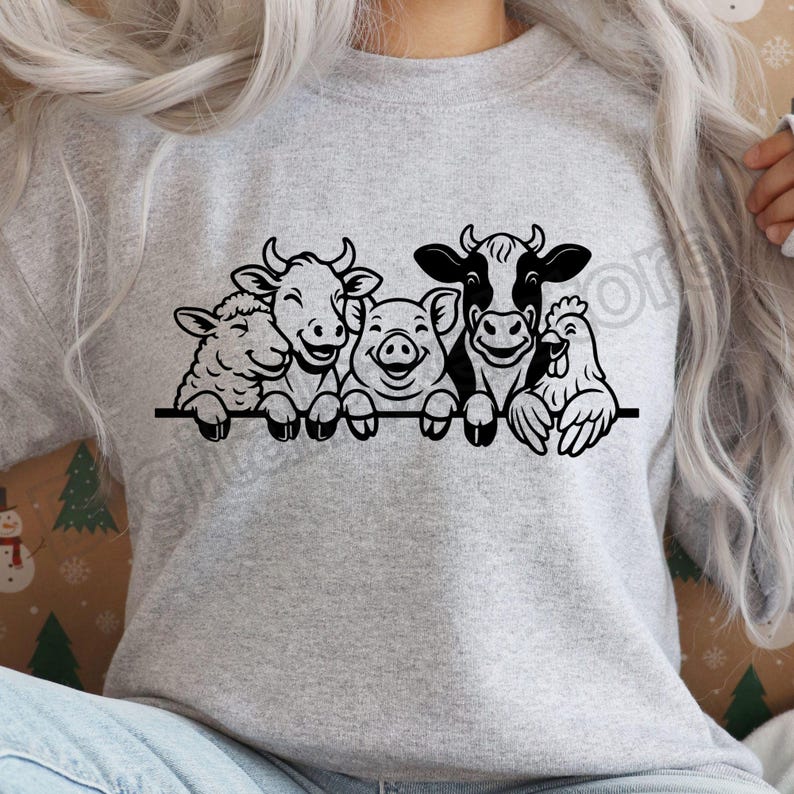 May include: A light grey sweatshirt with a black graphic of farm animals: a sheep, two cows, a pig, and a chicken. The animals are smiling and appear to be holding onto a black horizontal line. The sweatshirt is a light grey colour.