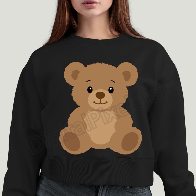 May include: Black sweatshirt featuring a cartoon teddy bear illustration. The bear is brown with a light brown belly and paws, a black nose, and a smiling expression. The design is centered on the front of the sweatshirt.
