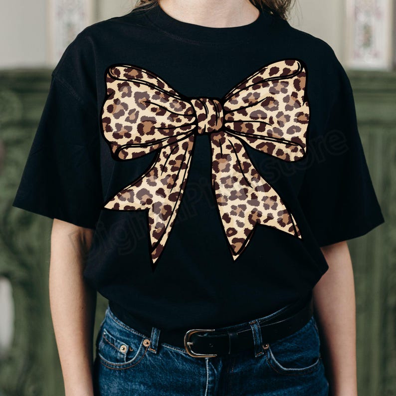 May include: Black t-shirt with a large leopard print bow design.