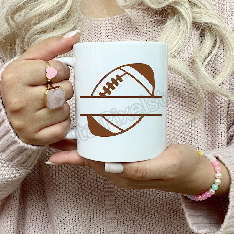 Pode incluir: Caneca de cer&acirc;mica branca com um design de bola de futebol marrom e um espa&ccedil;o em branco para personaliza&ccedil;&atilde;o. A caneca est&aacute; sendo segurada por uma pessoa que est&aacute; vestindo um su&eacute;ter rosa.