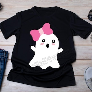 May include: Black t-shirt with a white ghost wearing a pink bow. The ghost has large eyes and an open mouth.