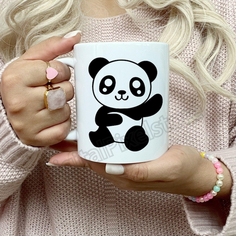May include: White ceramic mug featuring a black and white cartoon panda design. The panda is waving and has large eyes.