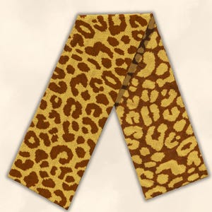 May include: A rectangular knit scarf featuring a repeating leopard print pattern in shades of dark brown and mustard yellow. The fabric has a visible textured weave throughout, and the scarf is displayed in a folded, inverted V-shape orientation.
