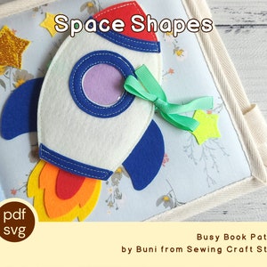Könnte beinhalten: Eine Filz-Beschäftigungsbuchseite mit einer weißen Rakete, blauen und roten Akzenten und einer gelb-orangen Flamme. Die Seite trägt den Titel "Space Shapes" und enthält einen goldenen Glitzerstern und ein grünes Band. Entworfen von Buni von Sewing Craft Studio.